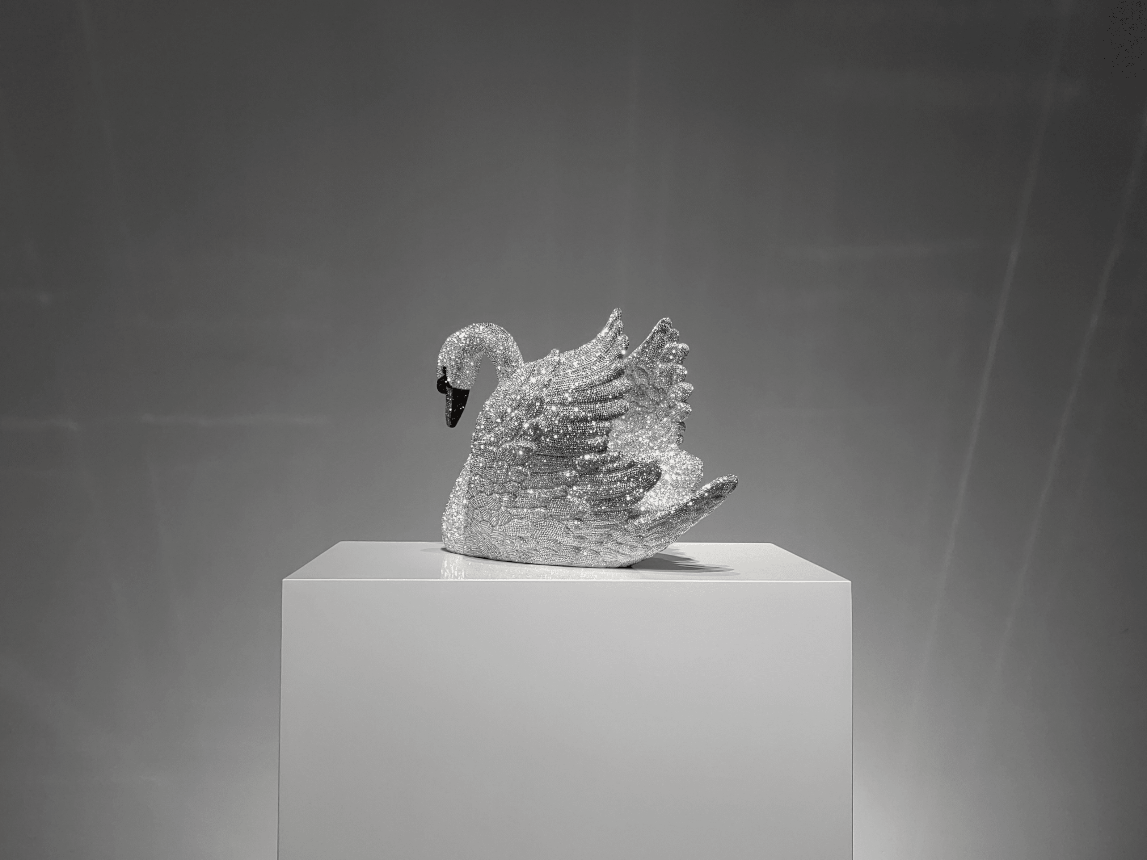 Rear view of VAGHAAR crystal swan sculpture highlighting layered wing detailing and crystal brilliance.
