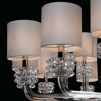 Close-up of Varella chandelier showing crystal arms, fabric shades, and diffused lighting detail