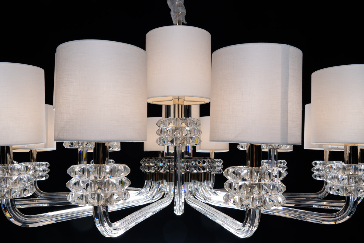 Close-up of the Varella crystal chandelier by HDLS, featuring sculptural crystal arms, faceted details and ivory shades.