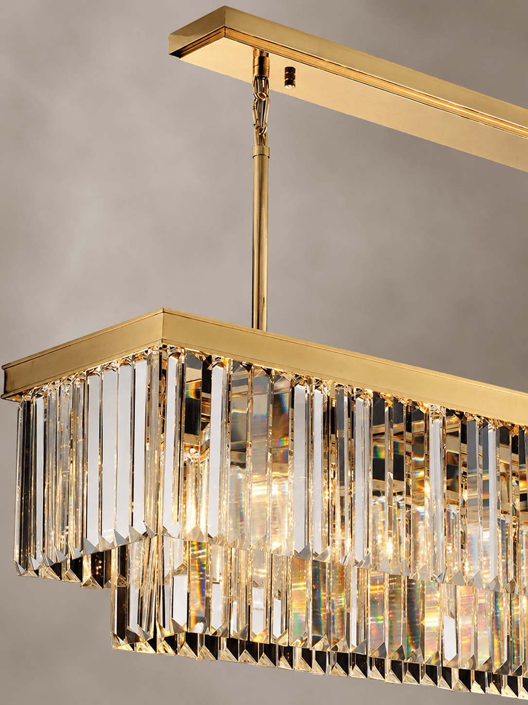 Close-up of Vendôme Prestige linear crystal chandelier with gold finish and faceted crystal prisms.