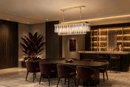 Luxury rectangular crystal chandelier above dining table in modern hospitality interior with burgundy accents.