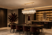 Luxury rectangular crystal chandelier above dining table in modern hospitality interior with burgundy accents.