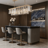 Vendôme Prestige 18K gold linear chandelier illuminating a luxury bar island, enhancing stone surfaces and modern interior design details.