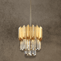 Luxury crystal pendant in 24K gold-plated stainless steel shown against textured wall
