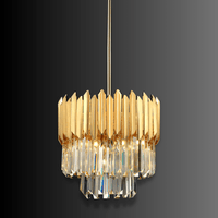 Luxury gold crystal pendant chandelier with faceted crystal tiers and polished gold frame on dark backdrop.
