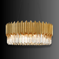 Zarrin Halo gold-plated crystal ring chandelier illuminated against dark gradient studio background.