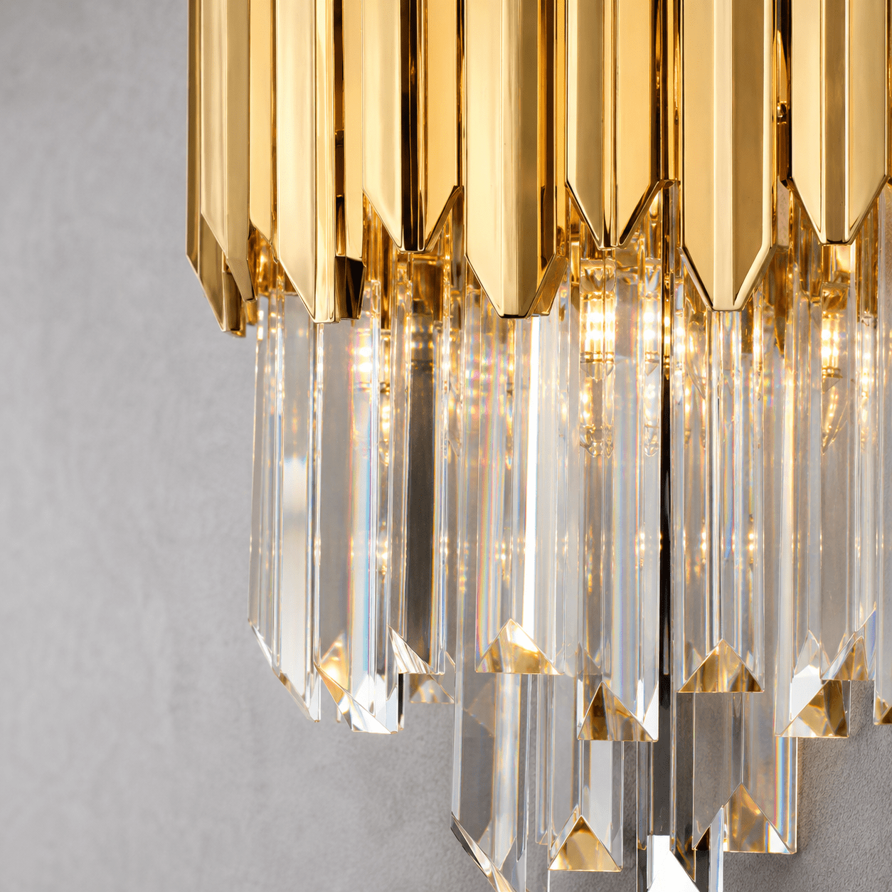Close-up of Zarrin Virelle 24K gold crystal wall sconce with precision-cut clear crystal prisms