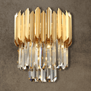 Luxury crystal wall light in 24K gold-plated stainless steel with layered crystal prisms on textured stone wall