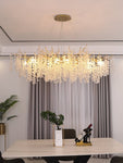 "Ethereal Vine Chandelier" installed in a living room with a dinning table with a bottle of wine on it.